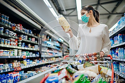 Young person with protective face mask buying groceries/supplies in the supermarket.Preparation for a pandemic quarantine Stock Photo