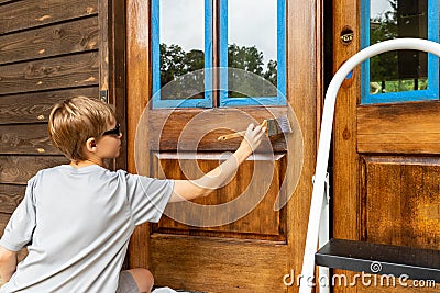 Young person works on repairing wooden door Stock Photo