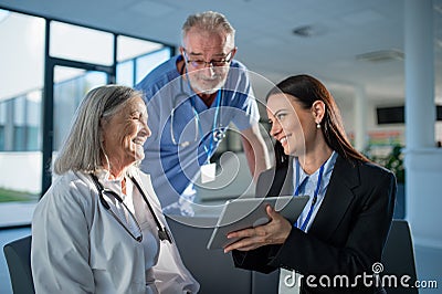 Young pharmaceutic seller explaining something to doctors in hospital. Stock Photo