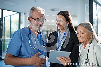 Young pharmaceutic seller explaining something to doctors in hospital. Stock Photo