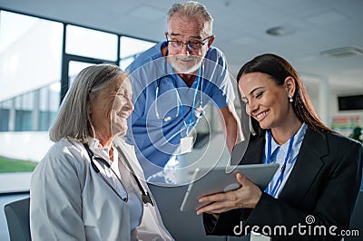 Young pharmaceutic seller explaining something to doctors in hospital. Stock Photo