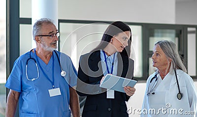 Young pharmaceutic seller explaining something to doctors in hospital. Stock Photo