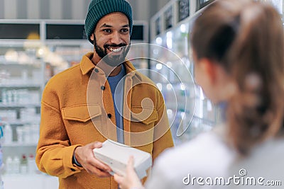 Young pharmacist helping customer to choos medication. Stock Photo