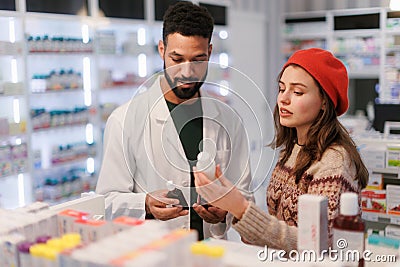 Young pharmacist helping customer to choos medication. Stock Photo