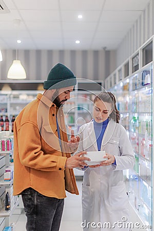 Young pharmacist helping customer to choos medication. Stock Photo