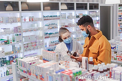 Young pharmacist helping customer to choos medication. Stock Photo