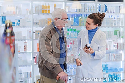 Young pharmacist helping senior man to choos medication. Stock Photo