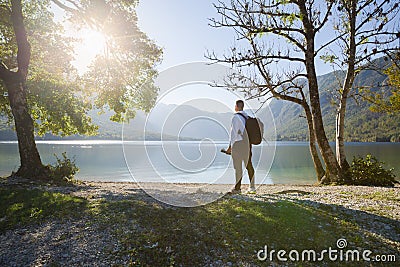 Young photographer looking at lake, on a beautiful sunny day Stock Photo