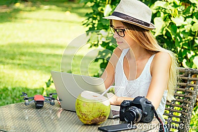 Young photographer woman feeling happy becouse she get money online while sitting at tropical cafe Stock Photo