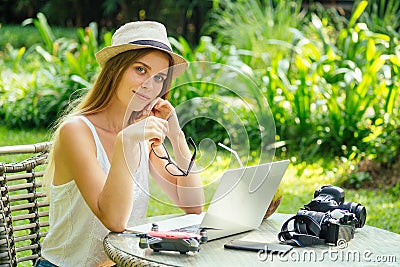 Young photographer woman feeling happy becouse she get money online while sitting at tropical cafe Stock Photo