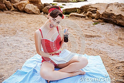 Young pin up girl holding glass bottle and winking Stock Photo