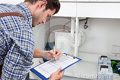 Young plumber with clip board Stock Photo