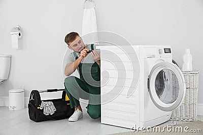 Young plumber fixing washing machine Stock Photo