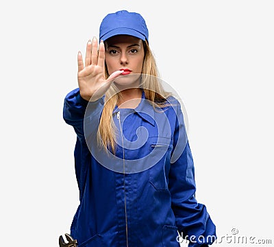 Young woman with plumber clothes isolated over grey background Stock Photo