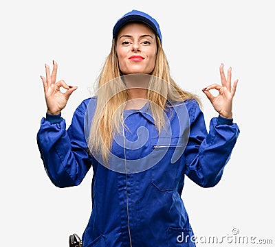 Young woman with plumber clothes isolated over grey background Stock Photo