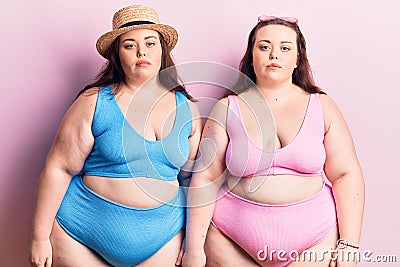 Young plus size twins wearing bikini with serious expression on face Stock Photo