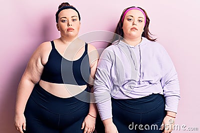 Young plus size twins wearing sportswear relaxed with serious expression on face Stock Photo