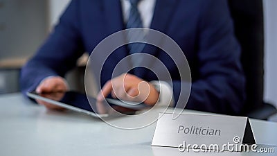 Young politician working on tablet computer, preparing electoral campaign Stock Photo