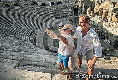 Young positive family take a self photo on the antique sights in Stock Photo