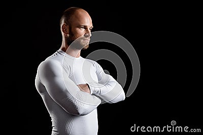 Young powerful sportsman in white clothing over black background. Stock Photo