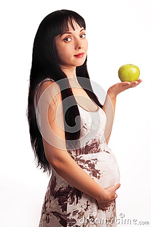 Young pregnant girl is eating an apple. Stock Photo