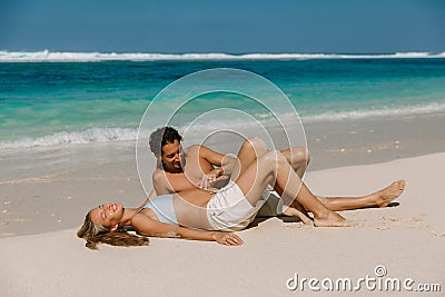 Young pregnant woman with husband at paradise beach. Happy couple at tropical island Stock Photo