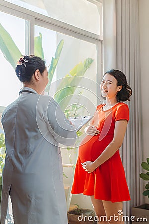 Young pregnant woman listening to prescription of doctor after regular examination at hospital Stock Photo