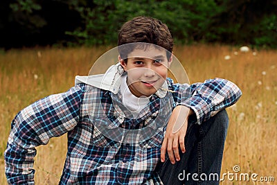 A Young Preteen Boy Chewing on Grass Stock Photo