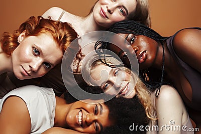 Young pretty african and caucasian women posing cheerful together on brown background, lifestyle diverse nationality Stock Photo