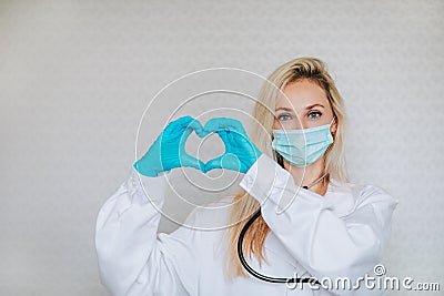 Doctor making the heart symbol by her hands on a white background with copy space Stock Photo
