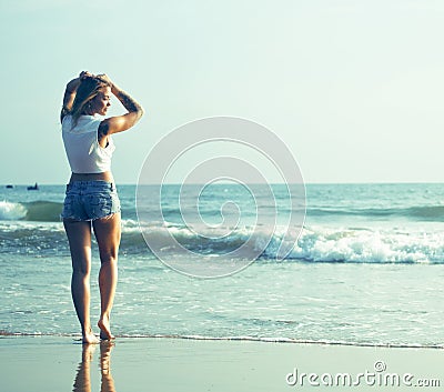 Young pretty blond woman at seacoast walking relaxing, fashion lady at sunset, lifestyle people vacations concept Stock Photo