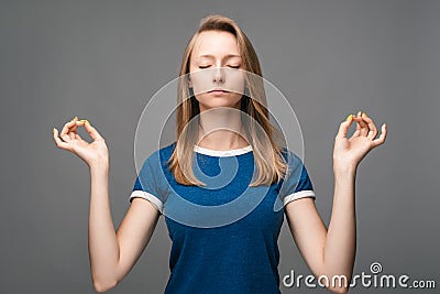 Young pretty Blonde woman meditates, his eyes closed, holds fingers in yoga sign. Relaxation concept Stock Photo