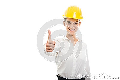 Young pretty business woman showing thumb up gesture wearing helmet Stock Photo