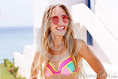 Young pretty fashion woman in red sunglasses posing outdoor in summer on tropic island in hot weather in bikini fashion photo of Stock Photo