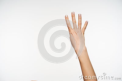 Young pretty female`s hand showing up four fingers while posing against white background, showing signs of counting with raised Stock Photo