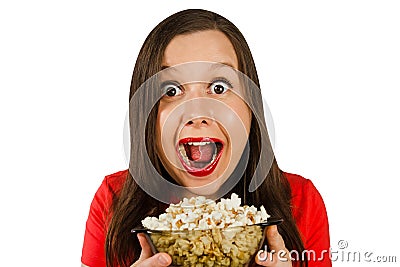 Young pretty girl with opened mouth and wide eyes holds glass bowl with popcorn isolated on white background Stock Photo