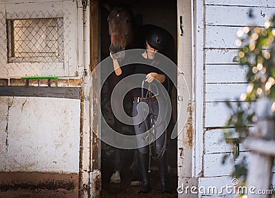 Young pretty girl - prepring horse for riding Stock Photo