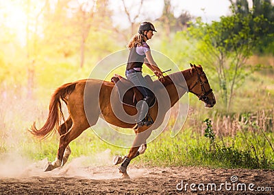 Young pretty girl riding a horse with backlit leaves behind in s Stock Photo