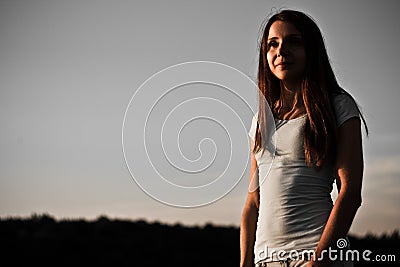 Pretty girl portrait in the sunset rays in low key Stock Photo