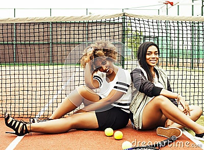 young pretty girlfriends hanging on tennis court, fashion stylis Stock Photo