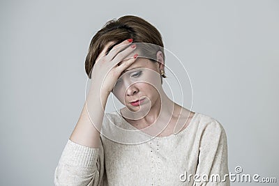 Young pretty and sad red hair woman looking worried and depressed crying and suffering headache and migraine pain and depression Stock Photo