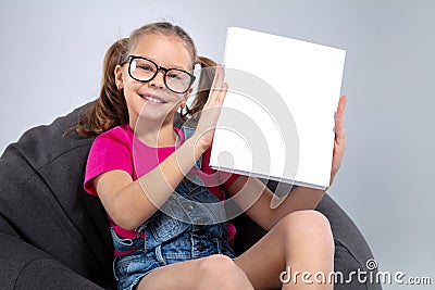 Young pretty school girl holding white book Stock Photo