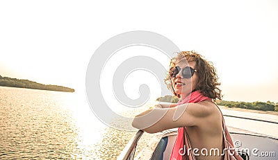 Young pretty solo woman traveler at sunset on boat trip Stock Photo