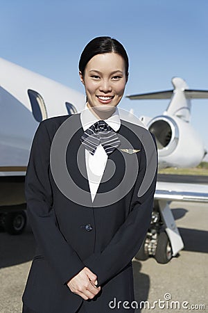 Young Pretty Stewardess Standing At Airfield Stock Photo