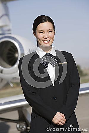 Young Pretty Stewardess Standing At Airfield Stock Photo