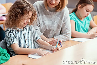 Pretty teacher solves homework together with the student Stock Photo