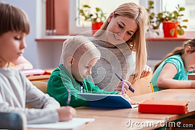 Pretty teacher solves homework together with the student Stock Photo