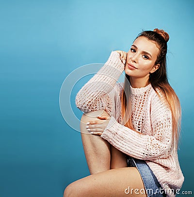 young pretty teenage modern hipster girl posing emotional happy on blue background, lifestyle people concept Stock Photo
