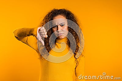 Young pretty woman standing on yellow studio background expressing discontent Stock Photo