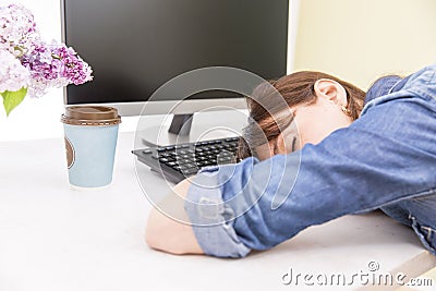 Young pretty woman tired and exhausted of work lying on table in front of computer and taking a break Stock Photo